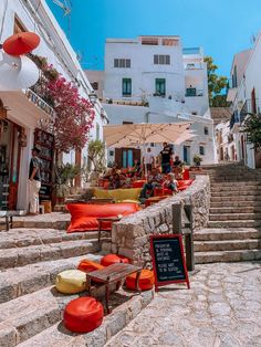 people are sitting at tables on the steps