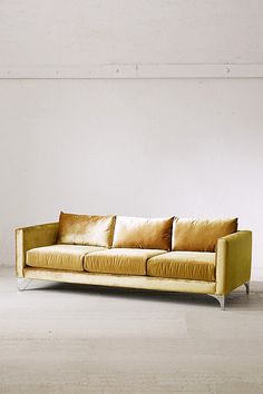 a yellow couch sitting on top of a white floor