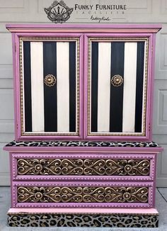 a pink and black dresser sitting on top of a cement floor next to a garage door