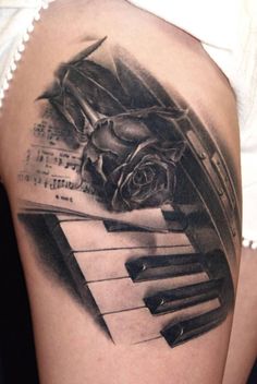 a black and white photo of a rose on top of a piano with music notes