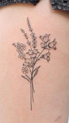 the back of a woman's thigh with flowers on her left side ribcage