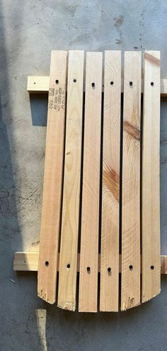 a piece of wood sitting on top of a wooden pallet next to a cement floor