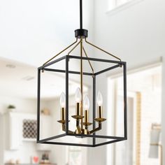 a chandelier hanging from the ceiling in a room with white walls and windows