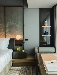 a hotel room with a bed, desk and chair in front of a large window