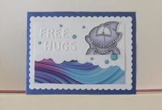 a close up of a greeting card with a shark on the front and free hugs on the back