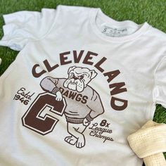 Designed and printed locally in Cleveland on a super soft heather dust unisex crewneck tee shirt with superior Airlume combed and ring-spun 100% cotton. *This product and its graphic design is not endorsed or licensed in any way by any team, or organization. SIZE BODY LENGTH CHEST WIDTH SLEEVE LENGTH CHEST TO FIT XS 27" 16.5" 8" 31"-34" S 28" 18" 8.25" 34"-37" M 29" 20" 8.625" 38"-41" L 30" 22" 9.5" 42"-45" XL 31" 24" 9.625" 46"-49" 2XL 32" 26" 10.25" 50"-53" 3XL 33" 28" 10.875" 54"-57" Retro Team Shirts, Varsity T-shirts, College Tee Shirts, Varsity Shirt Design, Vintage Sports Shirt, Sports Shirts Design, College Tshirt Designs, Basketball Team Shirts, Cleveland Browns Shirts