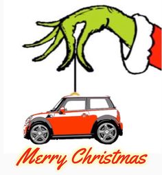 a red mini car with a hand holding a christmas sign on it's roof