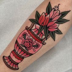 a pink vase with flowers and leaves on the arm is shown in this tattoo design