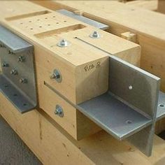 some metal brackets are attached to the side of a piece of wooden workbench