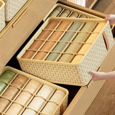 an open drawer with baskets on it and two people reaching for the items in them