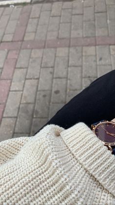 a pair of sunglasses sitting on top of someone's leg next to a white knitted bag