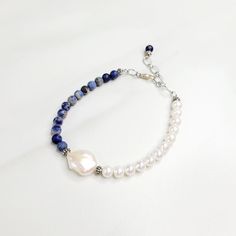 Deep blue sodalite beads are strung opposite luminescent freshwater pearls on our Blue Surf bracelet. One large coin shaped freshwater pearl divides the two. Handmade in the United States, a matching necklace is available. Features: - Sodalite Beads - Freshwater Pearls - Coin Shaped Freshwater Pearl - Etched Silver Plated Cable Chain - Lobster Claw Clasp - Extension - Handmade in the United States Dimensions: - Length: 7.5" - Extension: 1.0" - Total Length: 8.5" - Sodalite Beads: 6mm - Freshwate Sodalite Jewelry, Surf Bracelet, Boys Bracelets, Diy Wire Earrings, Blue Sodalite, Wire Earrings, Matching Necklaces, Cable Chain, Lobster Claw