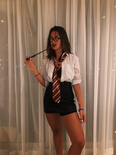 a woman dressed as harry potter holding a wand in her right hand and posing for the camera