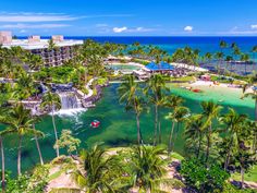 the resort is surrounded by palm trees and blue water