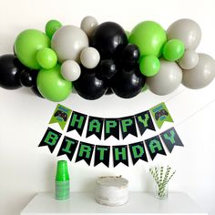 a happy birthday banner with balloons and streamers in the shape of black, white, and green