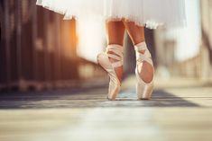 a ballerina's feet in ballet shoes on a sidewalk