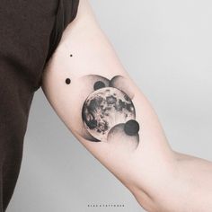 a man with a tattoo on his arm holding the moon and stars in front of him