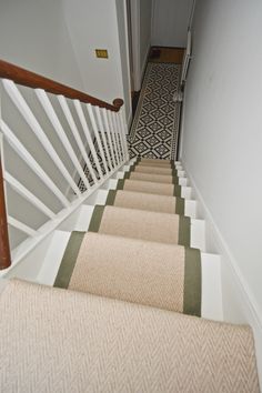 a staircase with carpeted steps leading up to the second floor and another door in the background