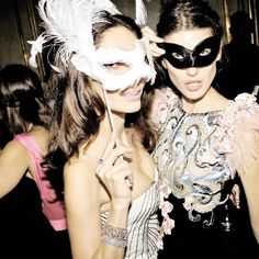 two women in masquerades pose for the camera