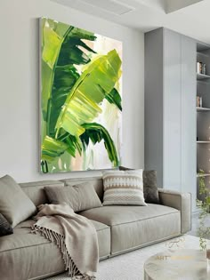 a living room with a couch, coffee table and painting on the wall above it