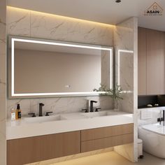 a bathroom with two sinks and a large mirror above the bathtub is illuminated by recessed lights