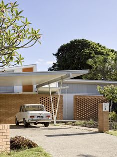 a car is parked in front of a house with an awning on the roof