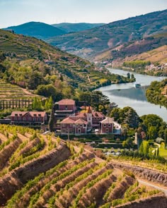 an aerial view of a large estate surrounded by hills and trees with a river running through it