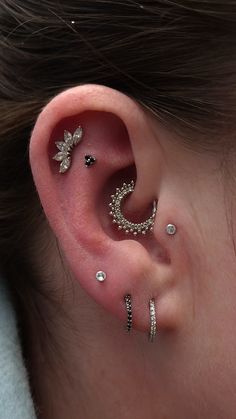 a woman wearing three different ear piercings