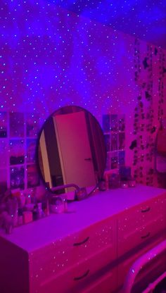 a bedroom with purple lights and stars on the wall behind it, there is a mirror that has been placed on top of a dresser