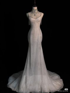 a white wedding dress on display in the dark