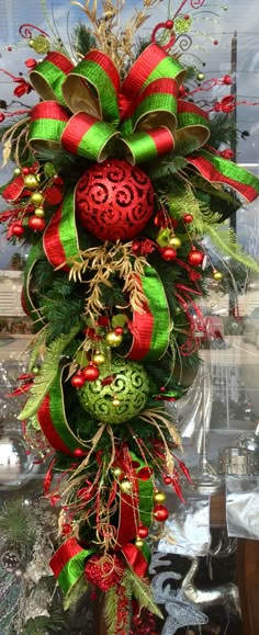 a green and red christmas wreath with ornaments