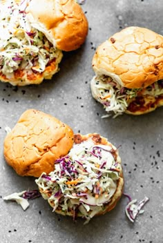 three sliders with coleslaw slaw on them