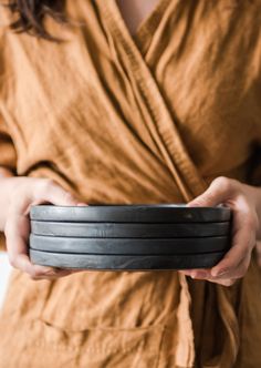 a woman holding a black tire in her hands