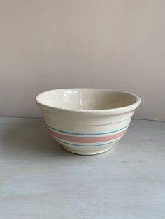 a white bowl sitting on top of a table next to a brown and blue wall