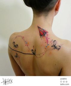 the back of a woman's neck with an origami kite on it