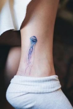 a small jellyfish tattoo on the ankle