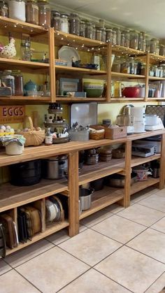 a kitchen filled with lots of wooden shelves covered in pots and pans