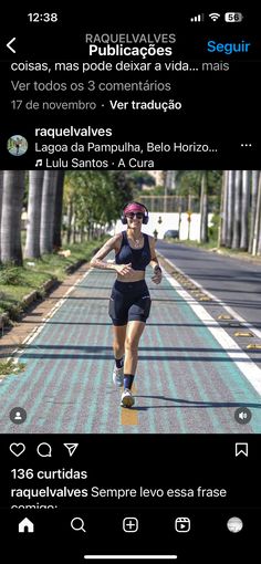 a woman running down a road with trees in the background and an instagramr on her phone