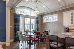 a dining room table and chairs in front of a large window