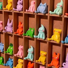 there are many different colored cat figurines on display