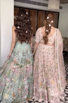 two women in long dresses standing next to each other