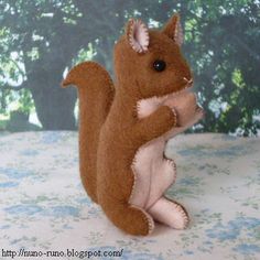 a stuffed squirrel is sitting on its hind legs and holding something in it's paws