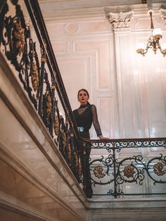 a woman standing at the top of a stair case