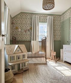 a baby's room with a crib, rocking chair and toy house on the floor