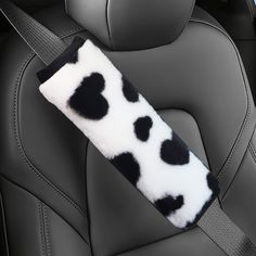 the seat belt cover is decorated with black and white spots