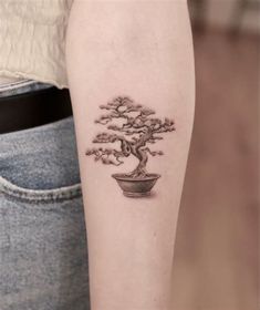 a small bonsai tree tattoo on the arm