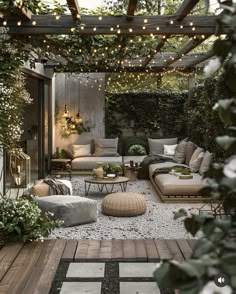 an outdoor living area with couches, tables and lights