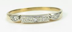 three stone diamond ring in yellow gold with white diamonds on the band and sidestones