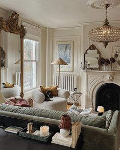 a living room filled with furniture and a fire place in front of a mirror on the wall