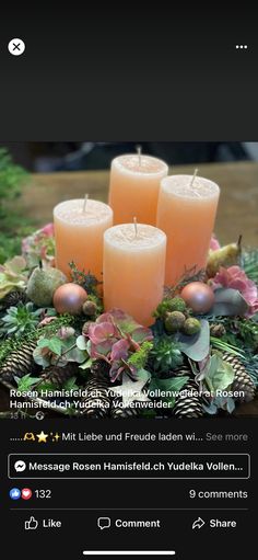 candles are arranged on a table with greenery